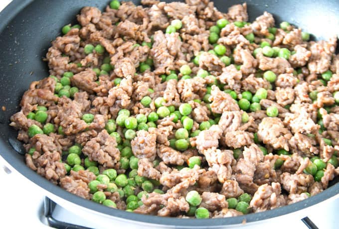 peas and Italian sausage in a pan
