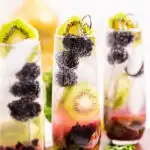 blackberry kiwi mojito recipe garnished with a cocktail pick of blackberries and a kiwi round